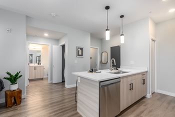 A modern kitchen with a white countertop and stainless steel appliances.